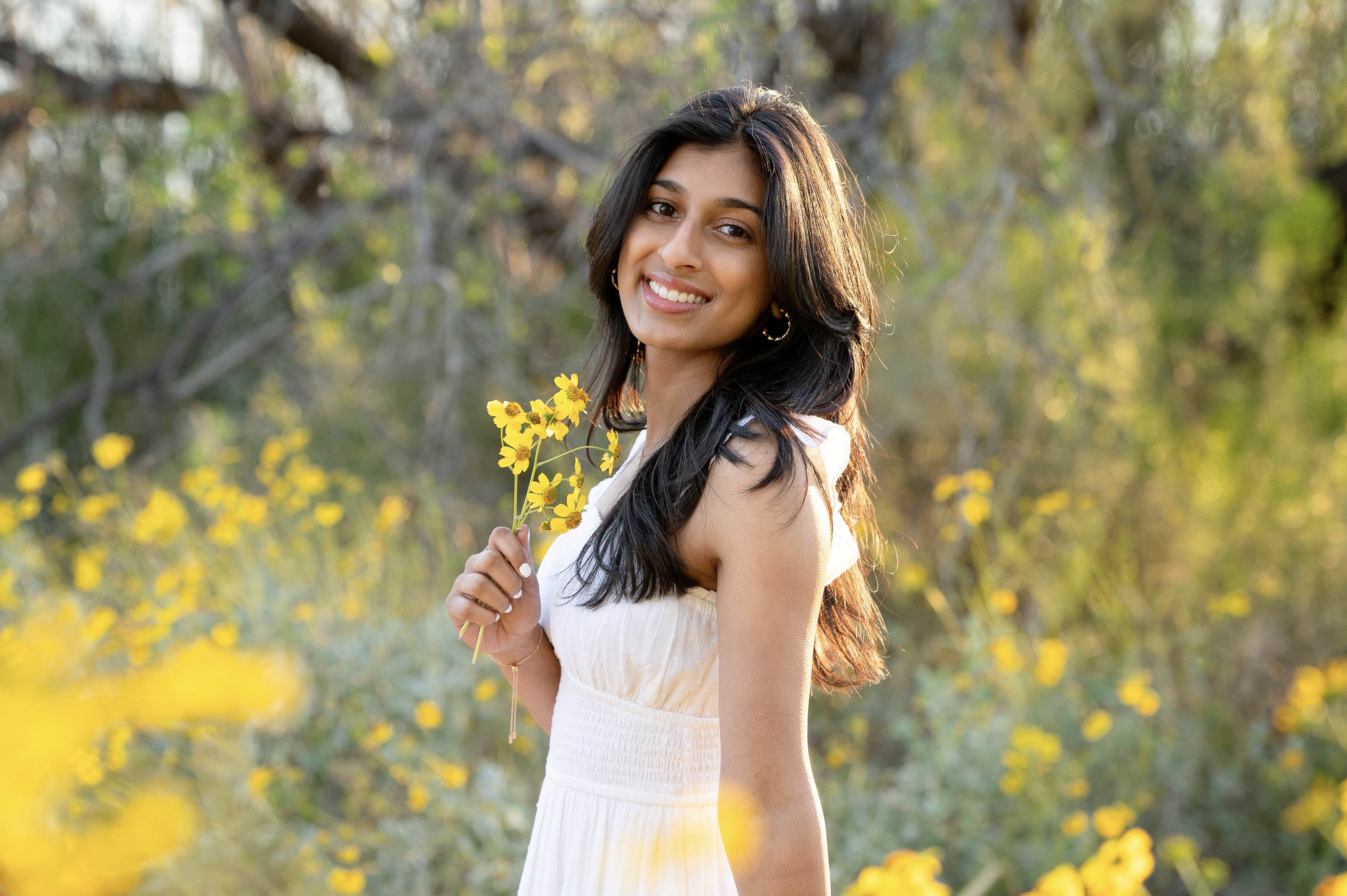 Neha holding yellow flowers outdoors